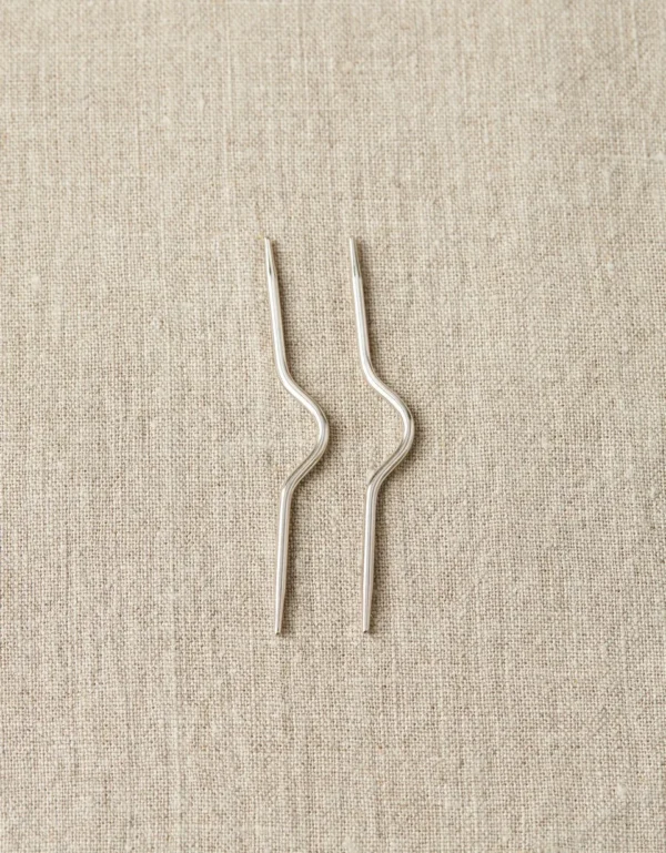 Two piece of metal pin on a cloth sheet