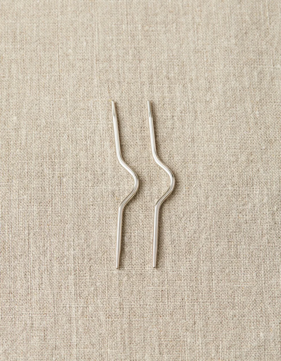 Two piece of metal pin on a cloth sheet
