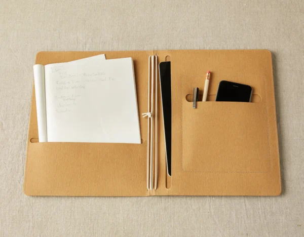 A file holder with paper, pen along with mobile phone in it